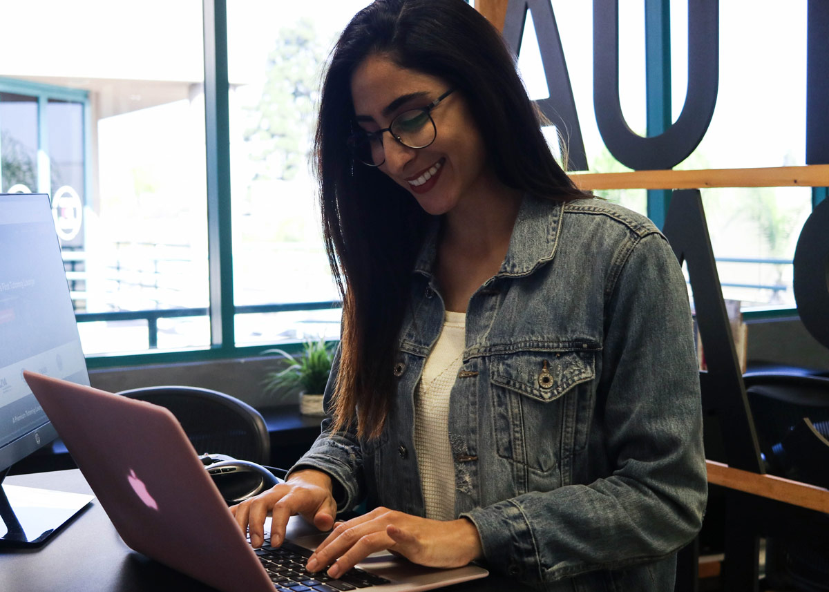 一个女人微笑着在电脑上打字