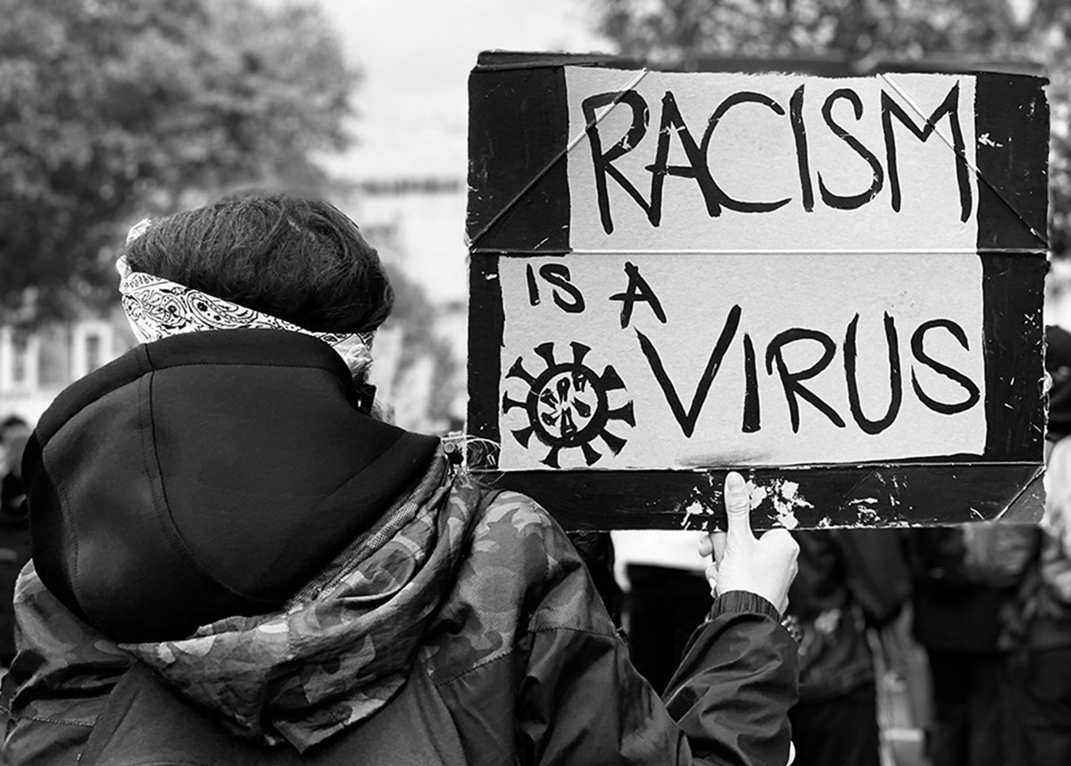 抗议者举着“种族主义是病毒”的标语