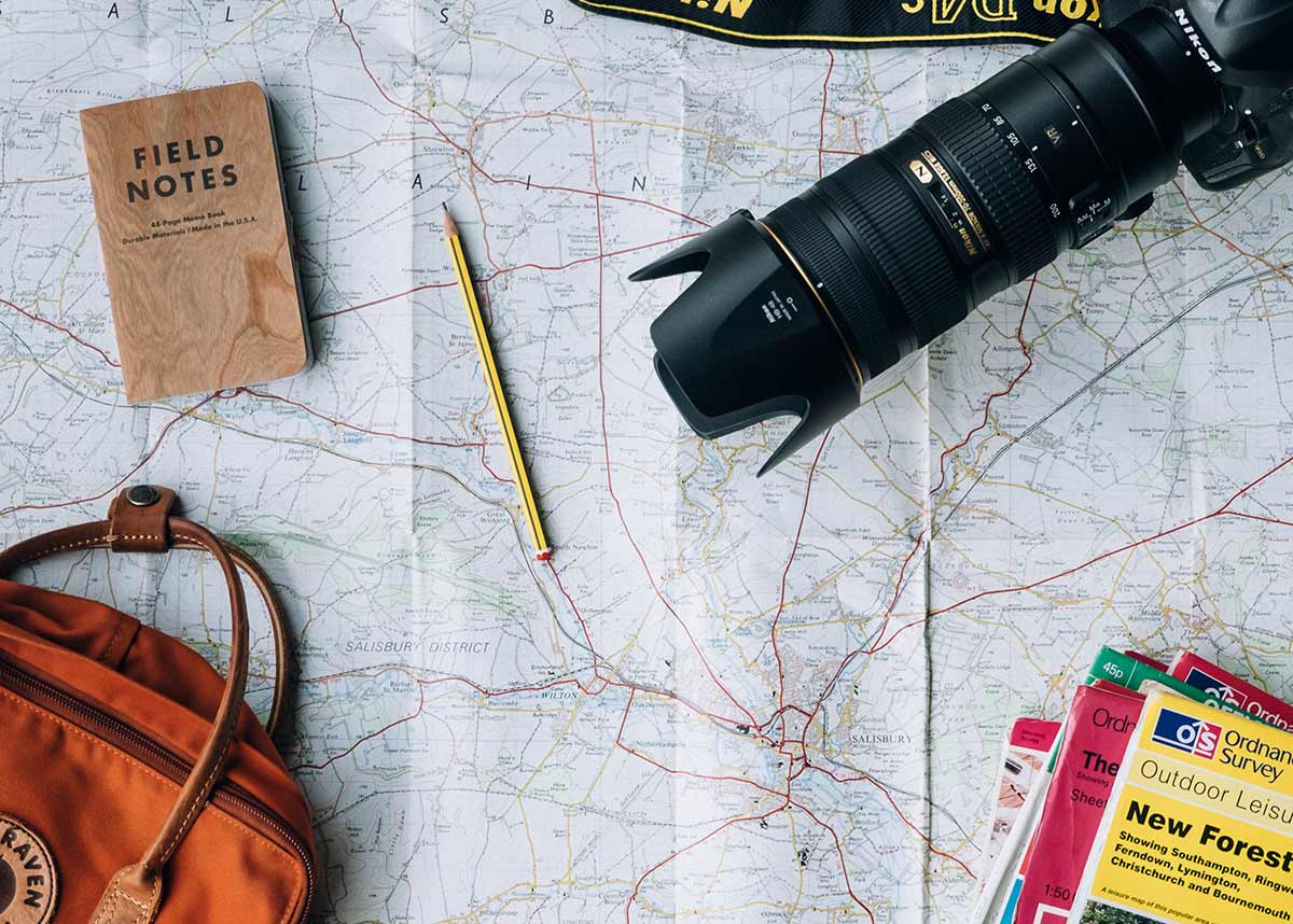 一张地图，上面有包、笔记本、相机和旅行指南