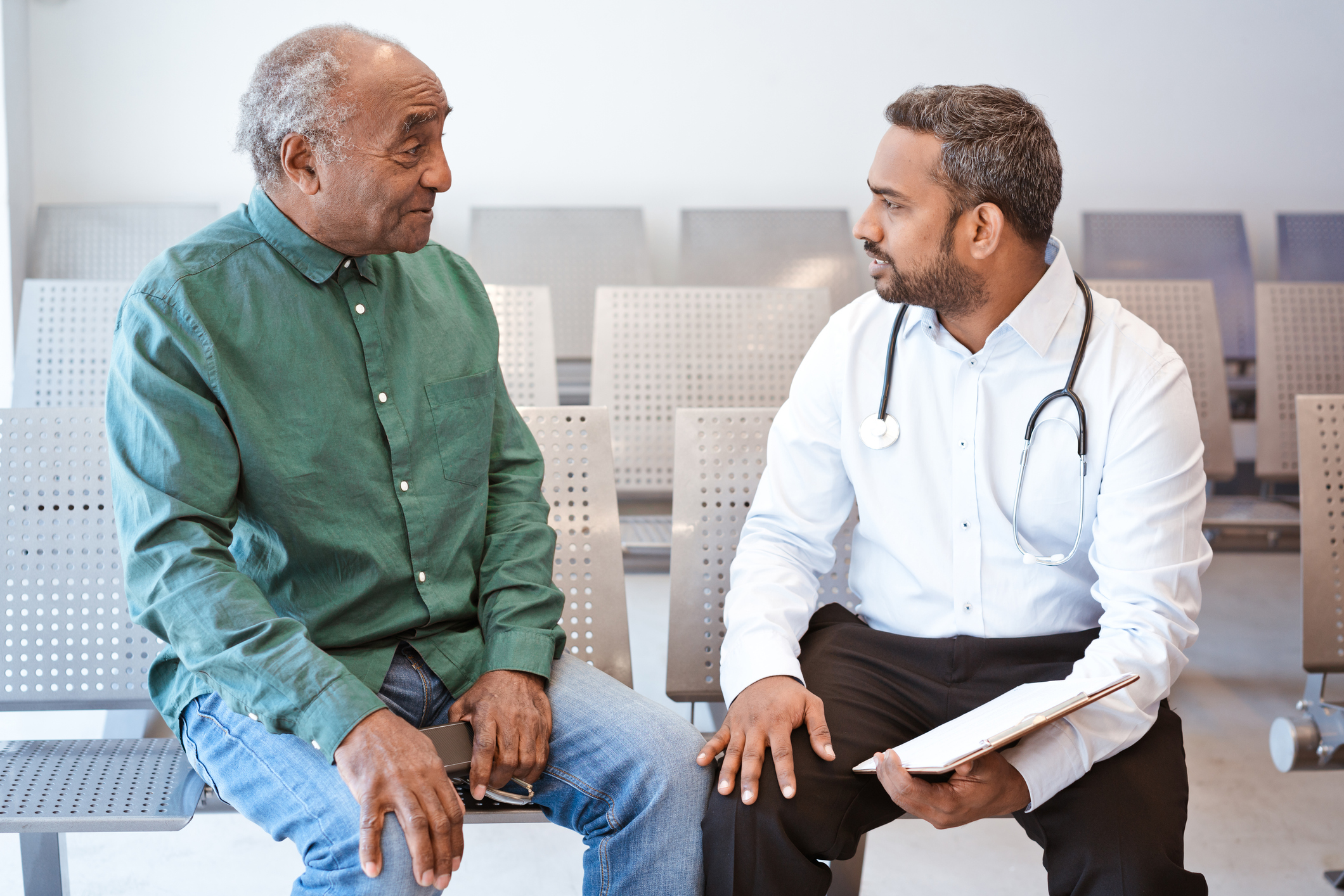 一位年长的非裔美国人正在和他年轻的医生交谈