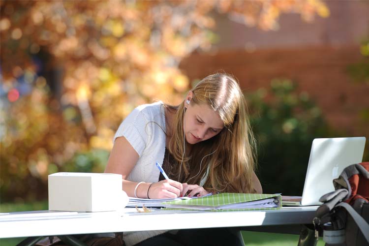 一个学生在外面的桌子上写字